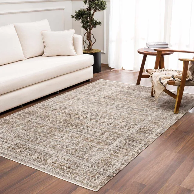 Beige and sage patterned area rug in front of a cream sofa.