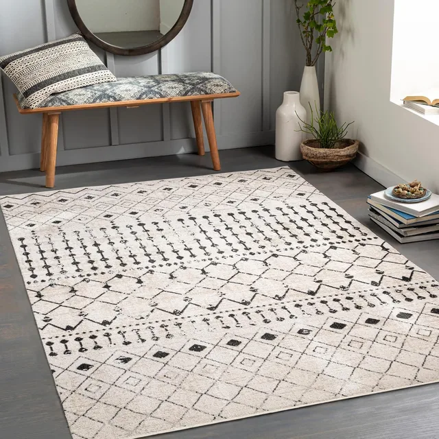 Light area rug with a black geometric pattern in a living room.
