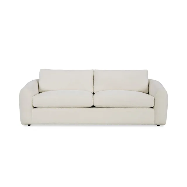 Cream upholstered two-seat sofa with curved arms and loose back cushions.